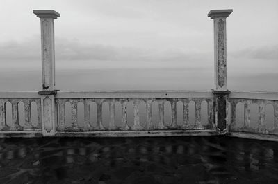 Close-up of railing by sea against sky