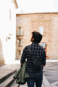 Rear view of man standing against building