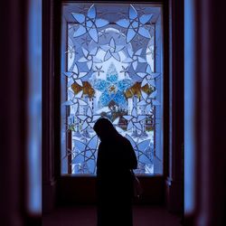 Silhouette woman standing in window