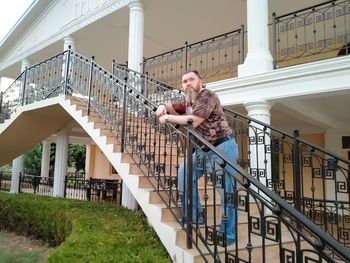 Man standing on staircase against building