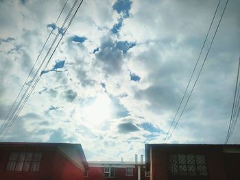 Low angle view of buildings against cloudy sky