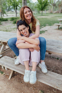 Portrait of young woman sitting on bench