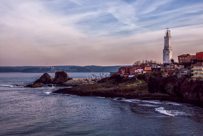 Lighthouse on landscape against sky