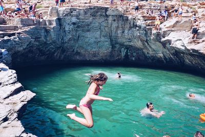 Teenage girl jumping in sea