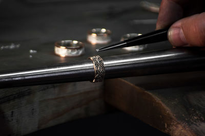 Close-up of hand of a goldsmith setting the diamond on the ring. craft jewelery