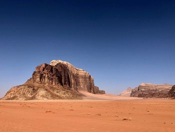 Rock formations in desert against clear blue sky