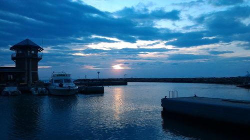 Boats in sea at sunset