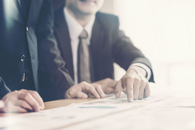 Midsection of man with hands on table