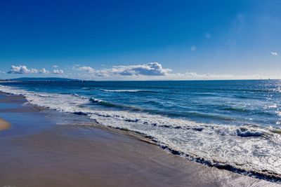 Scenic view of beach against blue sky