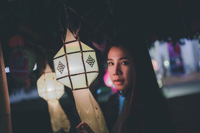 Portrait of beautiful woman standing at night outdoors