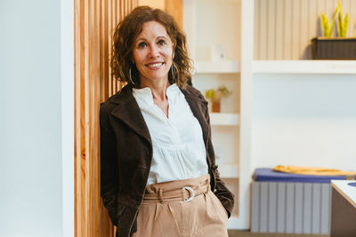 Portrait of smiling young woman standing at home