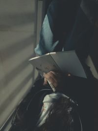 High angle view of man reading book on paper