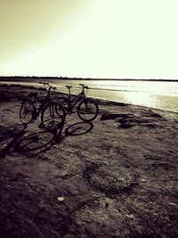 Bicycle on beach against clear sky