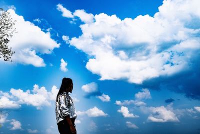 Low angle view of woman standing against sky