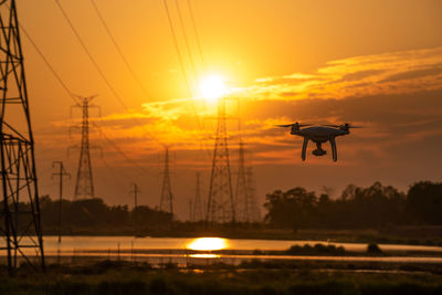 Silhouette of helicopter against sky during sunset