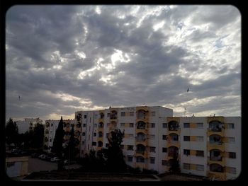 Buildings against cloudy sky