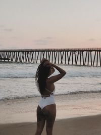 Full length of woman standing at beach against sky