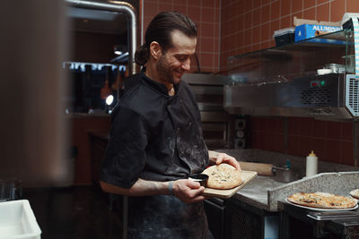 Portrait of young man preparing food at home