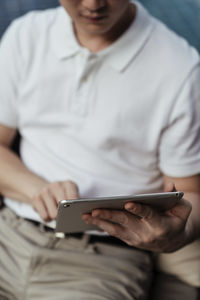 Midsection of man using mobile phone