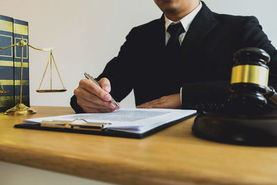 Midsection of man sitting on table