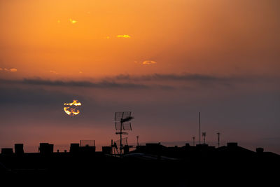 Silhouette buildings against sky during sunset