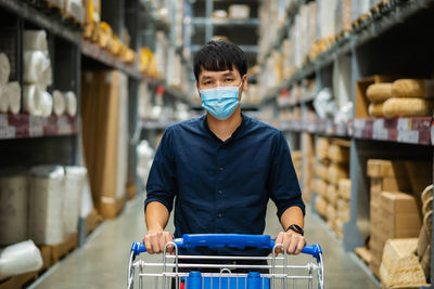 Portrait of man wearing mask working in warehouse