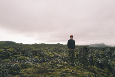 Man walking around lava filed covered in green moss in iceland