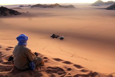 Man sitting on sand in desert