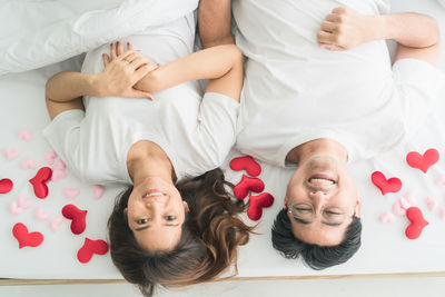 High angle view of friends relaxing on bed