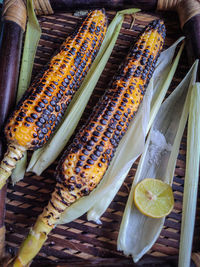 Spicy sweet corn burn in fire with lemon and salt in a wood tray from different angles