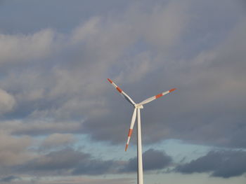 Low angle view of windmills against sky