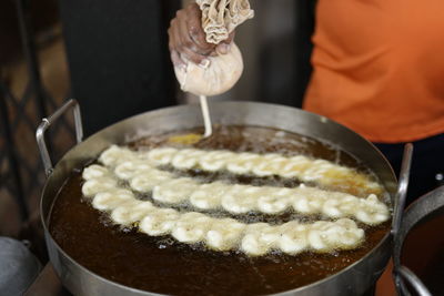 Close-up of person preparing jalebi