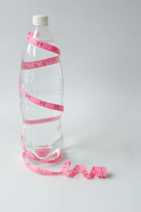 Close-up of pink bottle against white background
