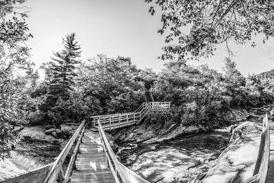 Railroad tracks by bridge against sky
