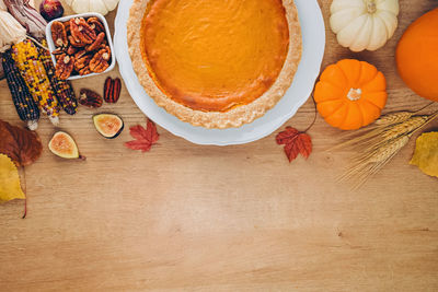 Thanksgiving composition with place for text. pumpkin pie, autumn harvest on the wooden table