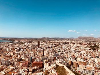 High angle view of city against blue sky