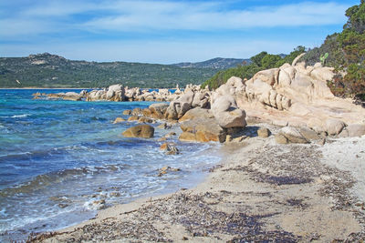 Rock formation on beach against sky