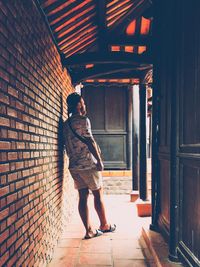 Full length of man standing against building