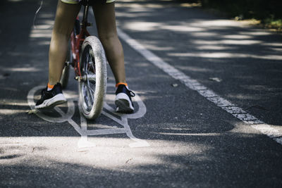 Low section of man riding bicycle on street