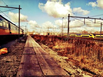 Surface level of railroad track against cloudy sky