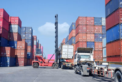 Vehicles on pier against sky