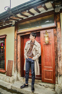 Full length of man standing at entrance of building