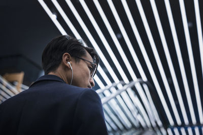 Handsome man with earbuds on escalator