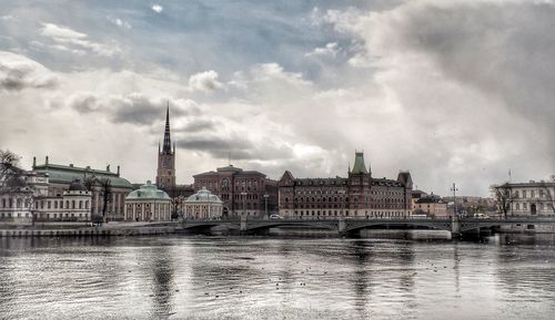 View of buildings in city against cloudy sky