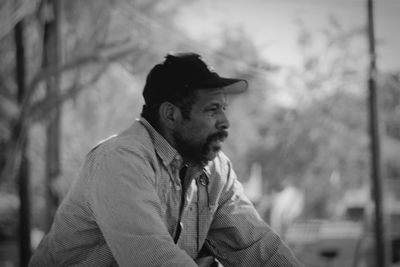 Portrait of young man looking away outdoors