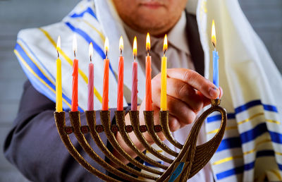 Close-up of priest igniting candles