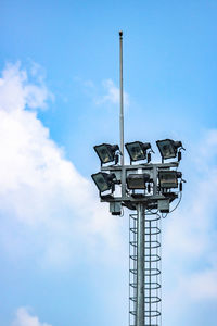 Low angle view of floodlight against blue sky