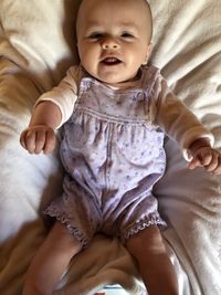 High angle view of baby lying on bed