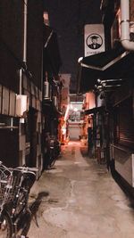 Narrow alley amidst buildings in city at night