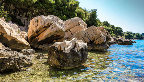 Rock formation in sea against sky